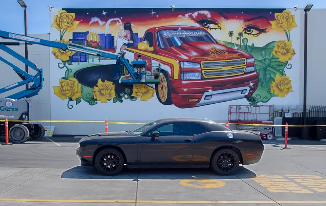 A car parked in front of the mural.