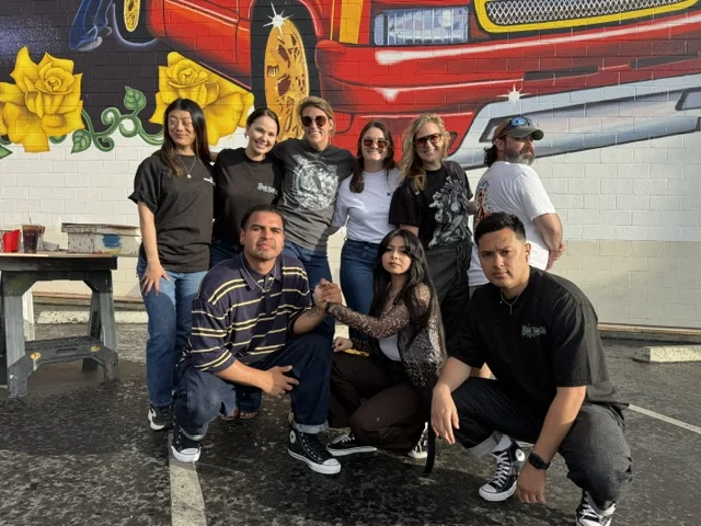 Crew members gathered in front of the mural.